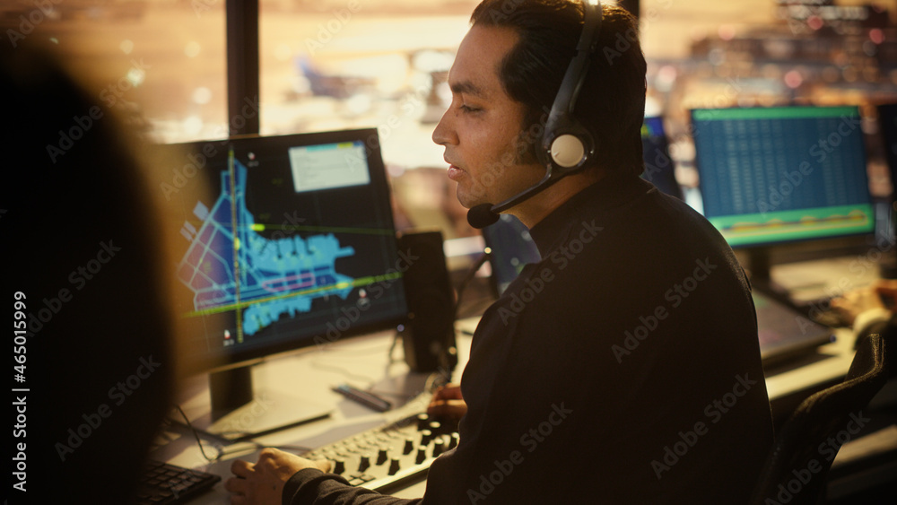 Portrait of Male Air Traffic Controller with Headset Talk on a Call in Airport Tower. Office Room is