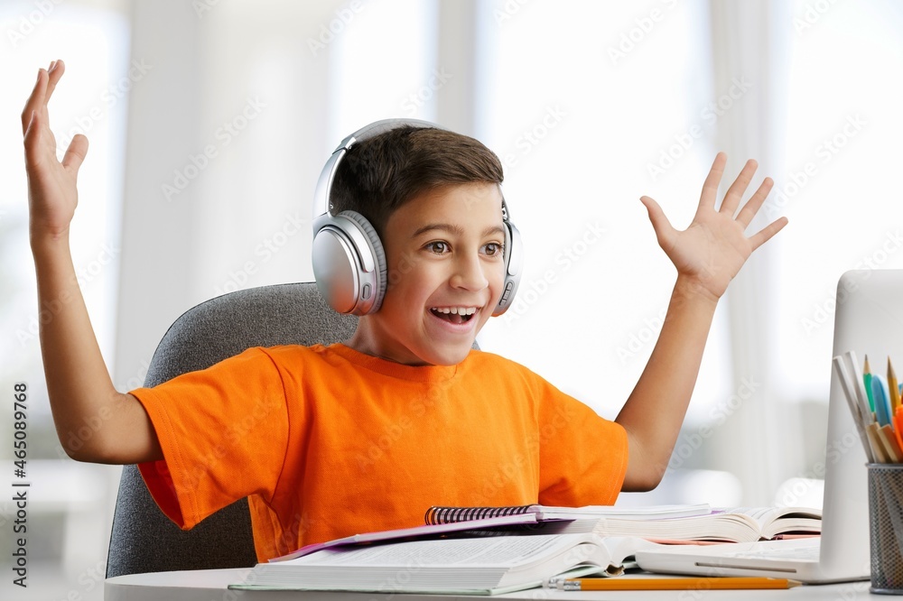 使用笔记本电脑和耳机在家学习的小孩，