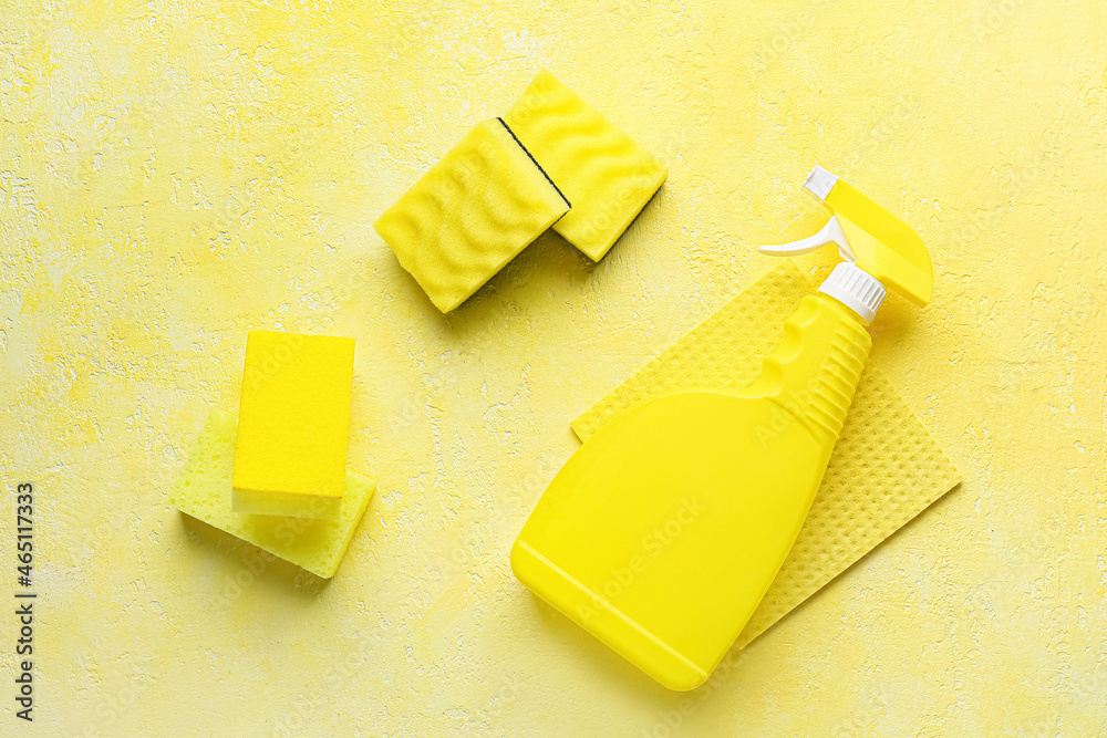 黄色清洁海绵和彩色背景的洗涤剂瓶
