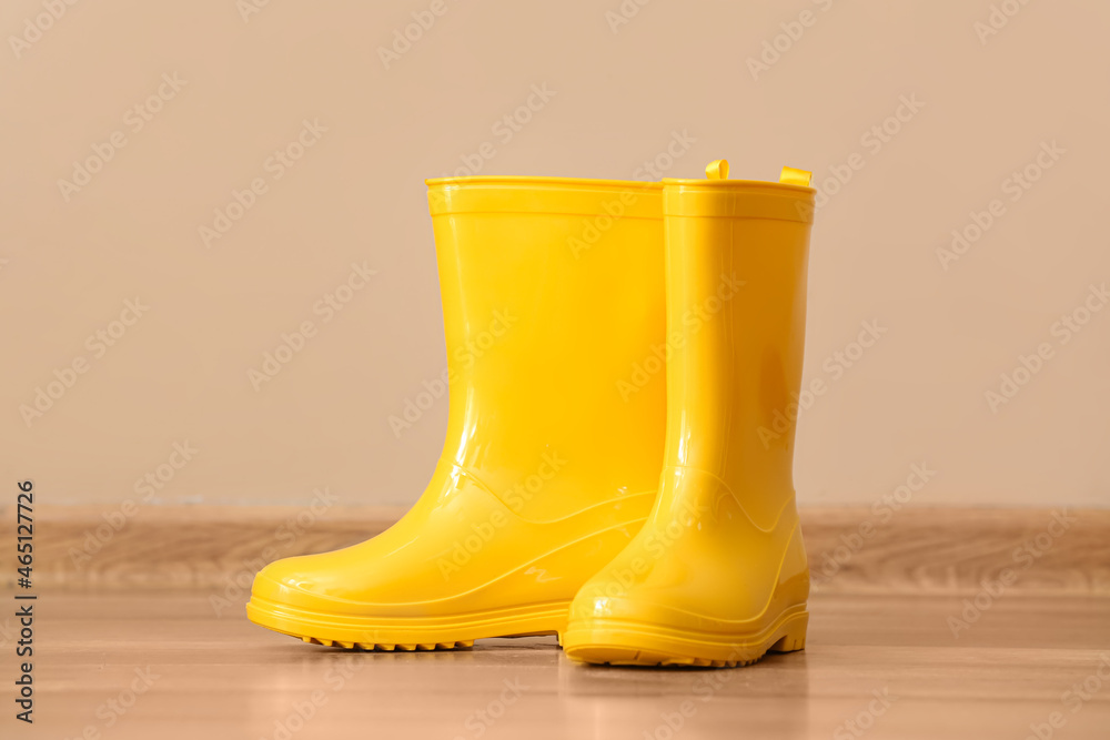 一双黄色橡胶靴，背景为彩色