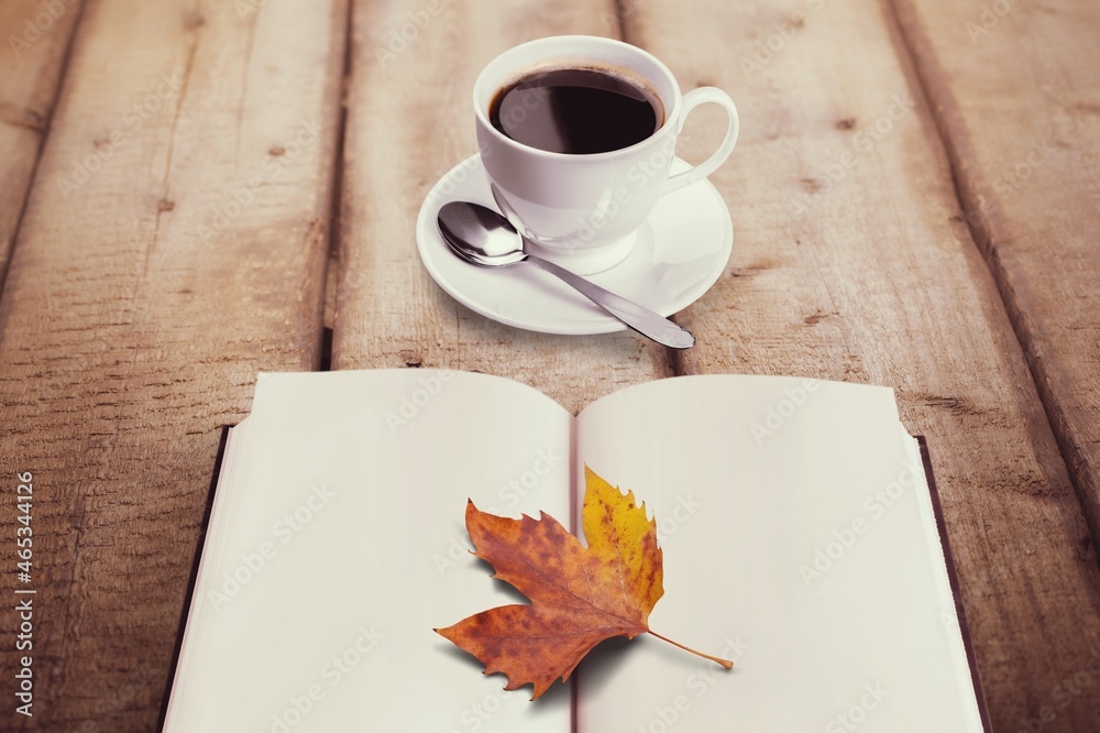 秋天，在一张乡村的木桌上放一本带时尚钢笔的空白日记，上面放着一杯咖啡