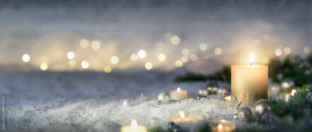 圣诞装饰，蜡烛、灯光、冷杉树枝和雪上的装饰品，全景格式
