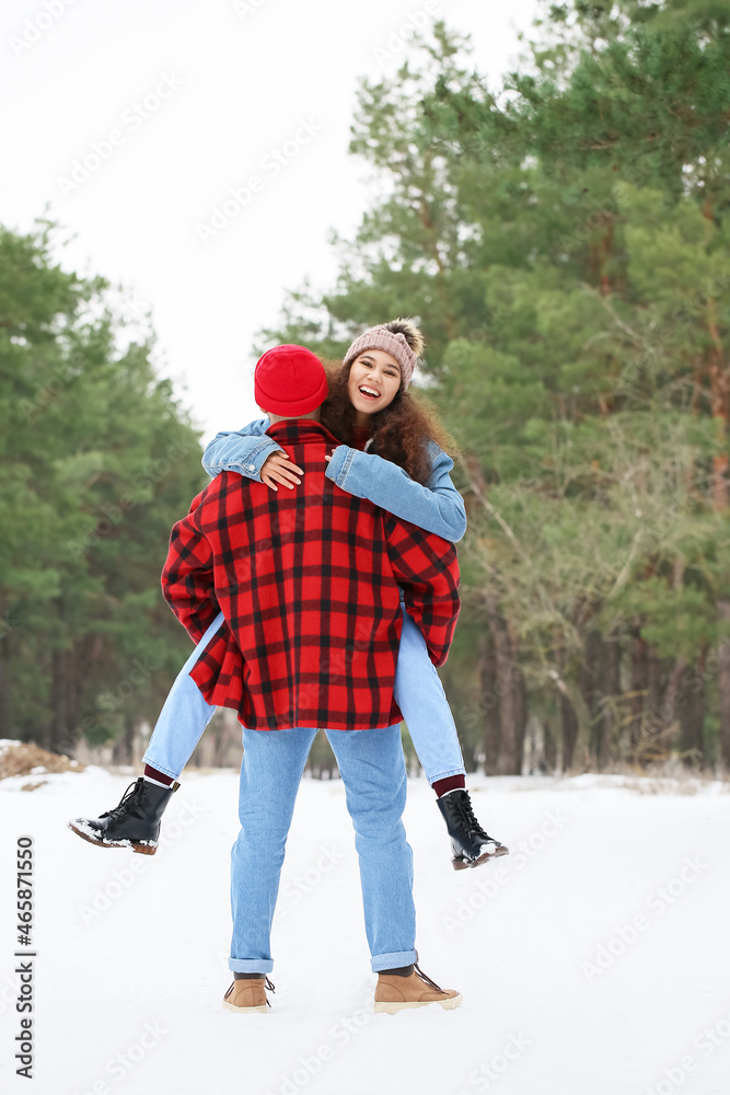 快乐的年轻夫妇在冬日的森林里玩得很开心
