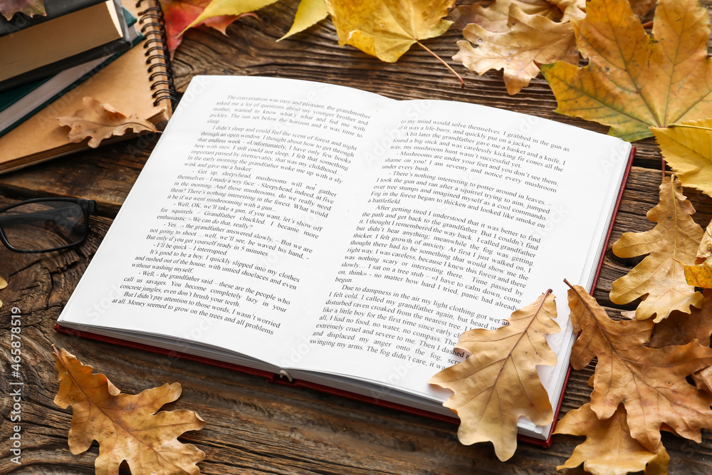 打开书本，木质背景下的秋叶