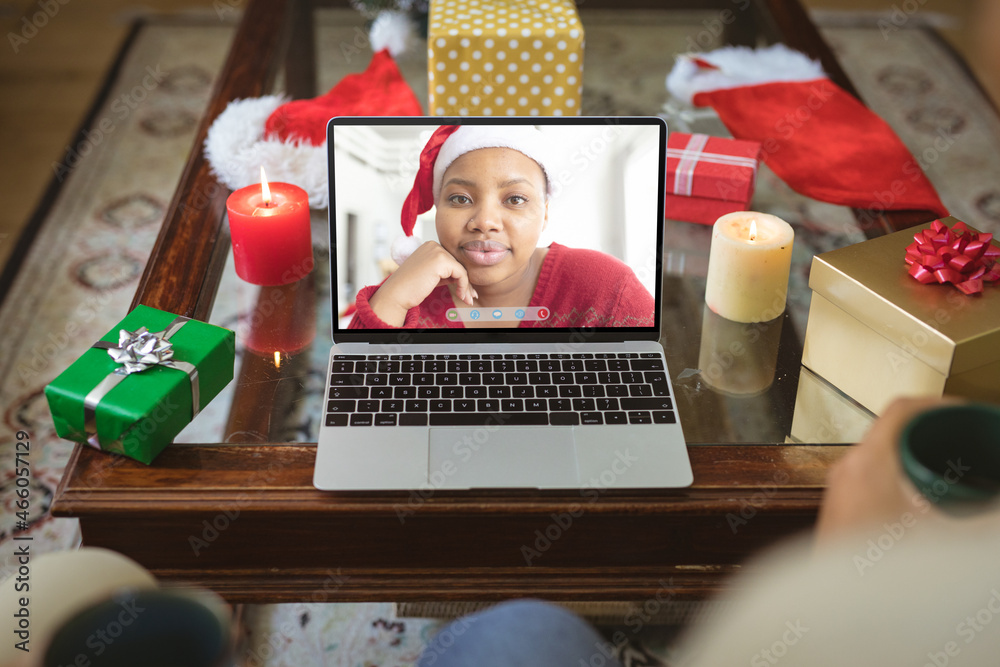 Smiling african american woman in santa hat on laptop christmas video call screen