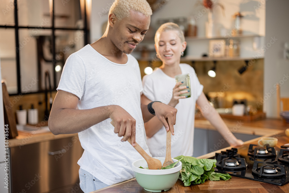 多种族夫妇在家厨房吃有机沙拉。健康饮食的理念。关系的概念