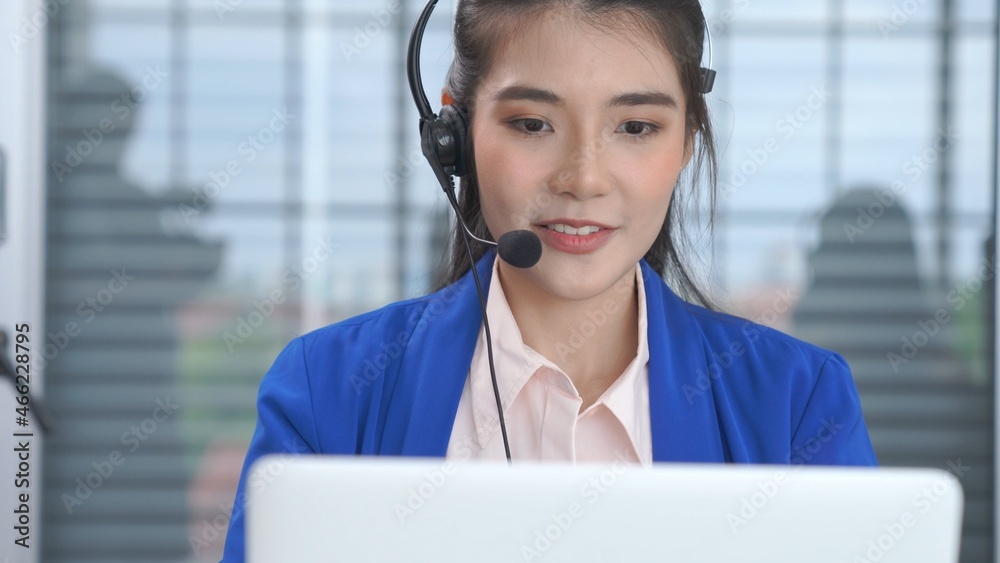 戴着耳机的女商人在办公室积极工作。呼叫中心、电话营销、客户支持