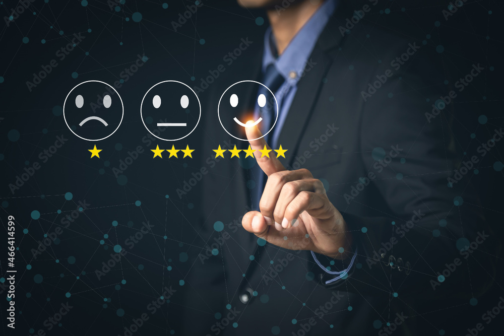 客户服务和满意度概念商人在虚拟屏幕上触摸快乐的笑脸图标
