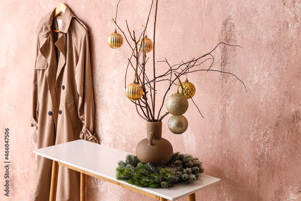 粉色走廊桌子上花瓶里有圣诞球的树枝