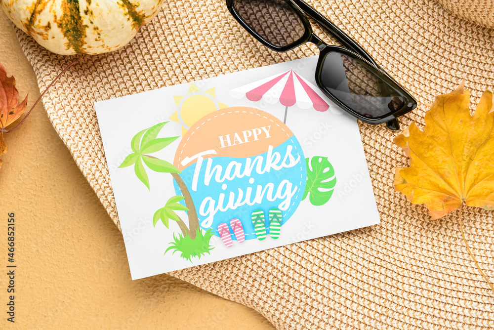 沙滩帽、南瓜、太阳镜、干树叶和纸质卡片，彩色背面印有文字HAPPY THANKSGING