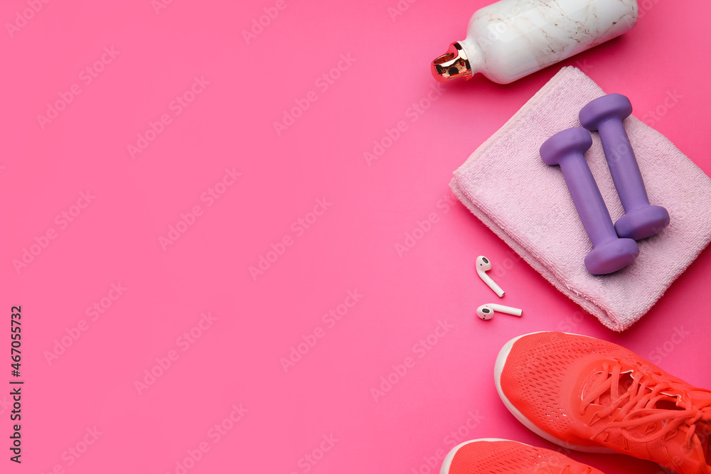 粉色背景的哑铃、鞋子和耳机