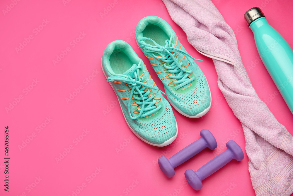 粉色背景的哑铃、毛巾和鞋子
