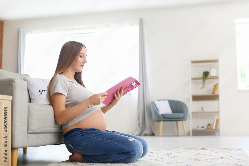 年轻孕妇在家阅读时尚杂志