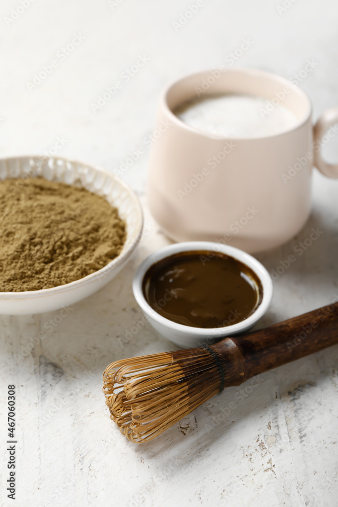 Bowl with hojicha green tea and chasen on light background