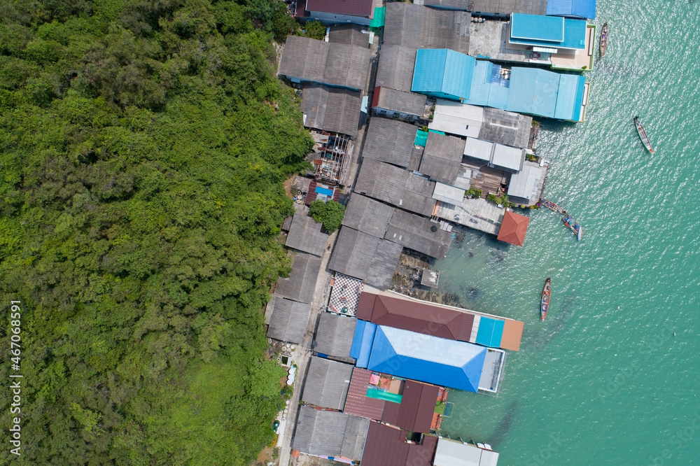 Aerial view top view of the fisherman village with fishing boats and house roof at the pier in koh r