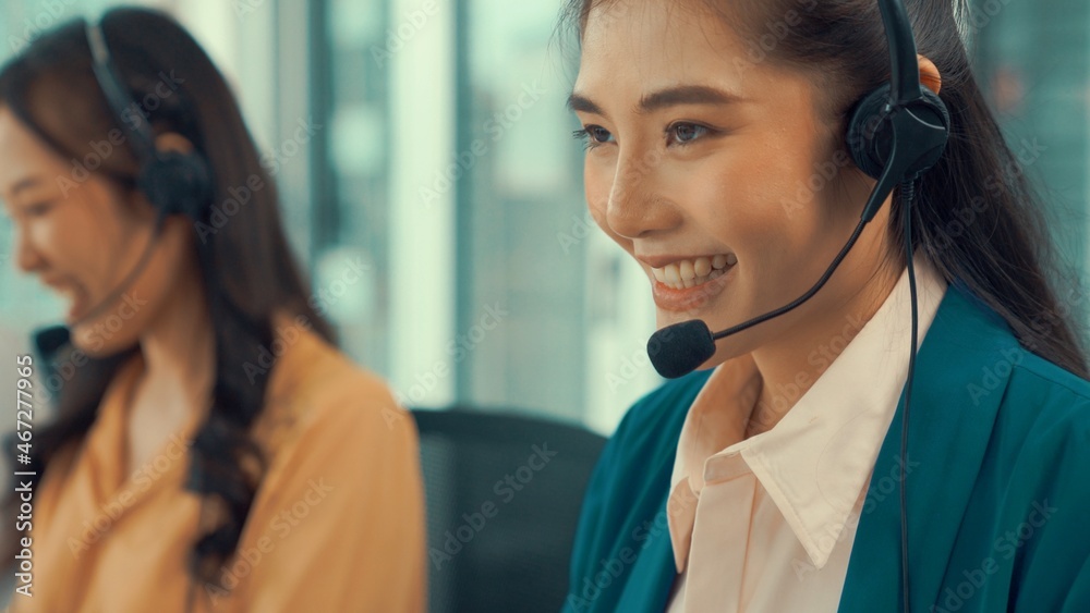 戴着耳机的女商人在办公室积极工作。呼叫中心、电话营销、客户支持