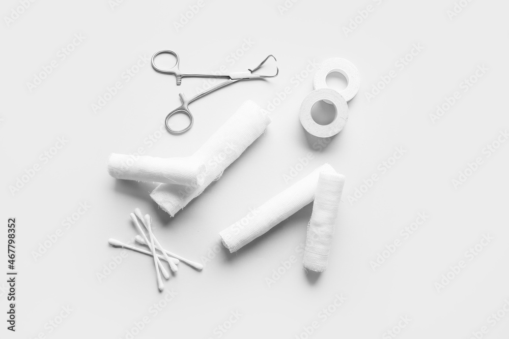 手术工具、绷带卷、医用膏药和浅背景棉签