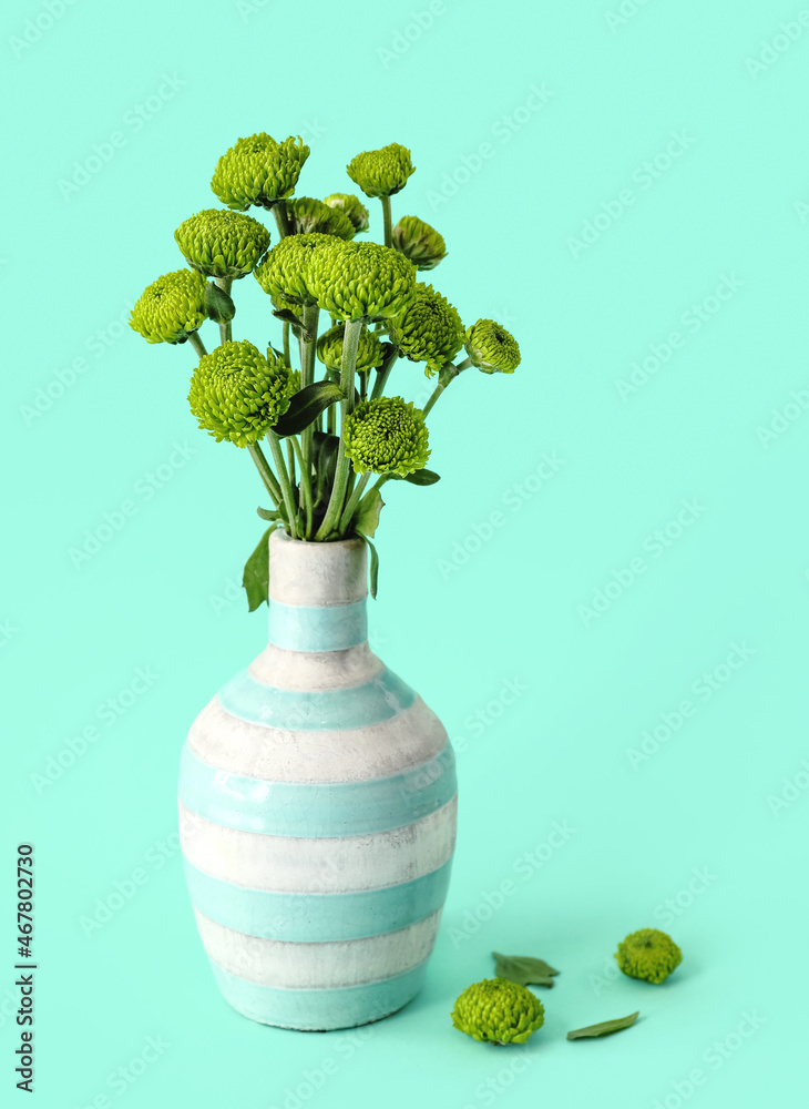 彩色背景上有绿色菊花的花瓶