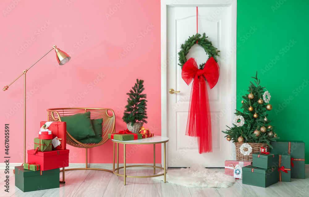 房间内部装饰白色门，靠近彩色墙的圣诞树和礼物