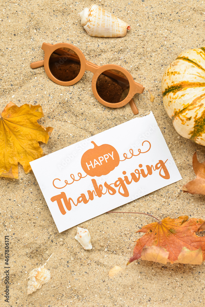 干树叶、太阳镜、南瓜、贝壳和纸卡片，上面写着祝你感恩节快乐
