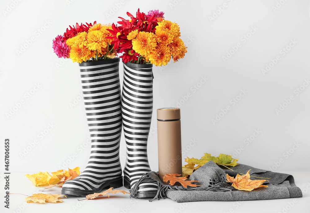 一双橡胶靴，白色背景上有菊花、保温瓶、围巾和落叶