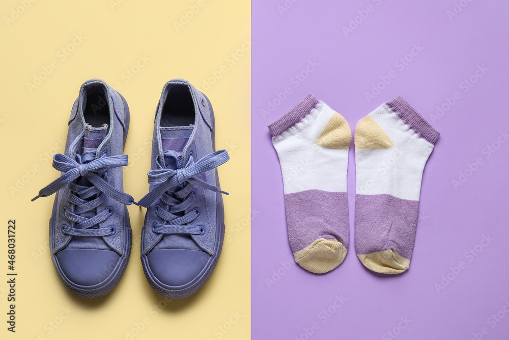 Stylish shoes and socks on color background
