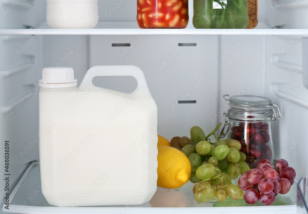 冰箱货架上的一加仑牛奶和产品