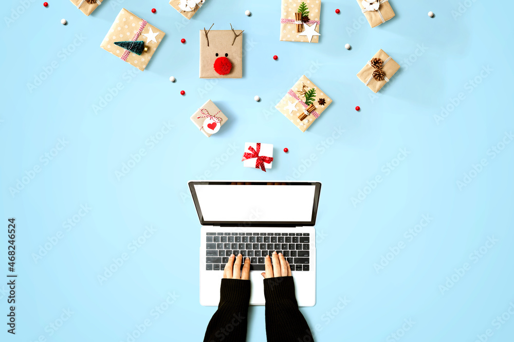 Person using a laptop computer with Christmas gift boxes from above
