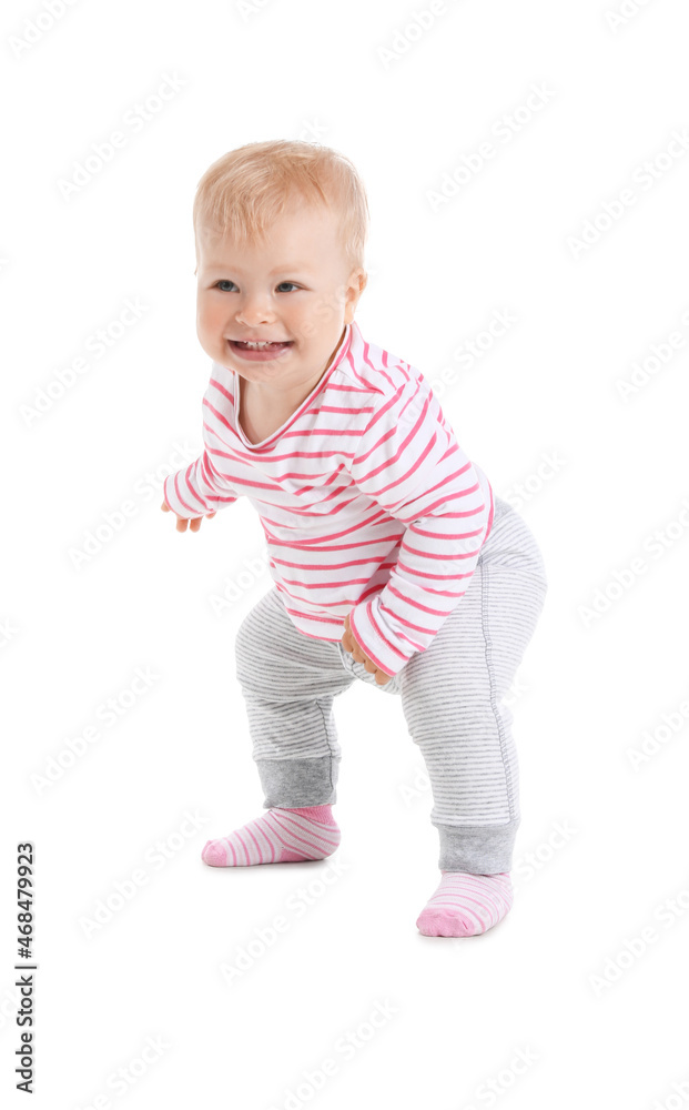 Cute baby girl learning to walk on white background