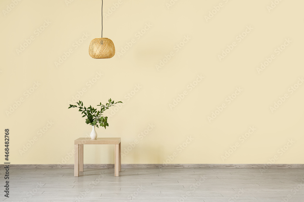 Table with houseplant and lamp hanging in big room