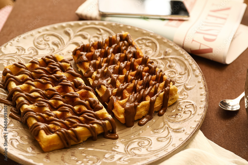咖啡馆桌子上摆着一盘美味的比利时华夫饼配巧克力