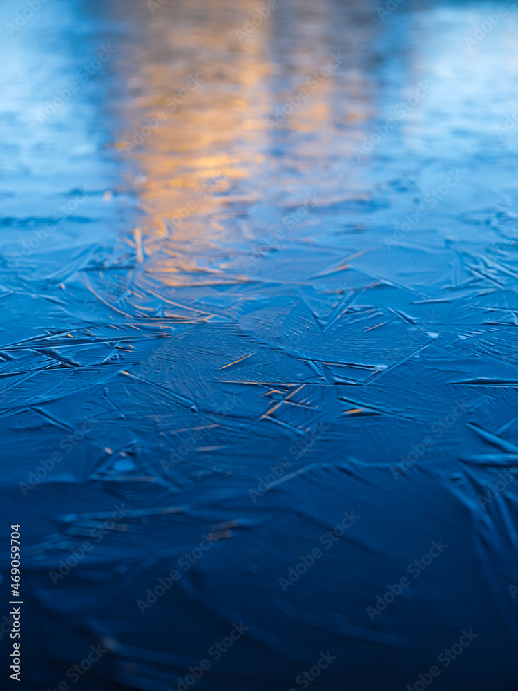 A frozen lake and reflections on the surface. Mountains during dawn. Abstract background. Detail in 