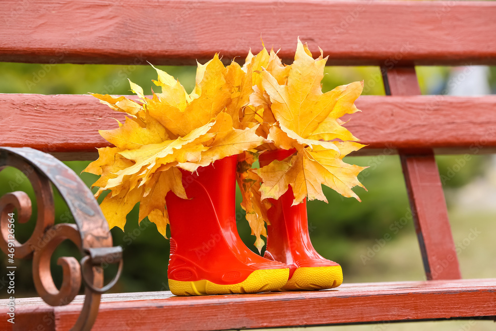 长椅上的一双秋叶橡胶靴，特写