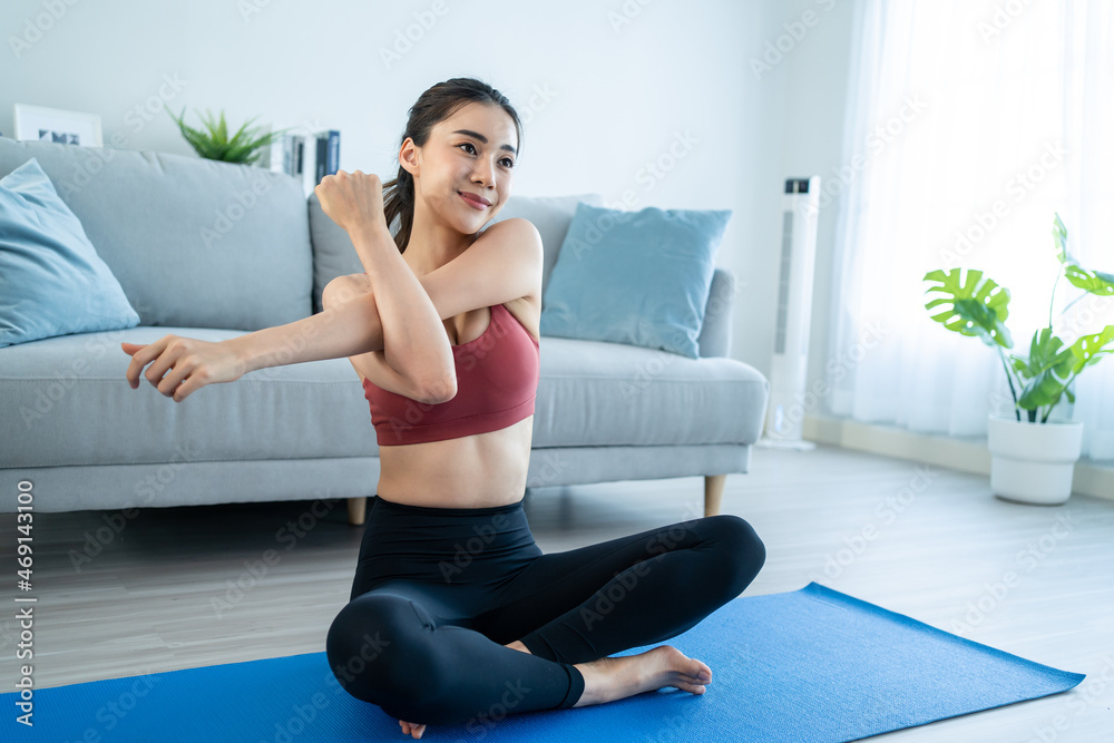 亚洲年轻漂亮的活跃女性在家做瑜伽普拉提锻炼。