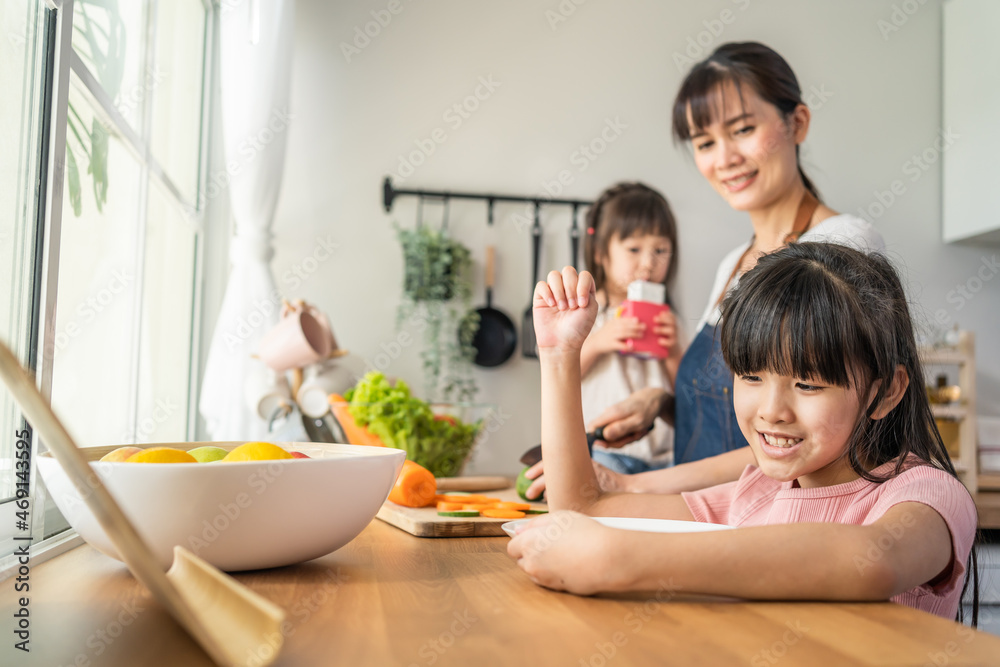 亚洲幸福家庭，妈妈和小女儿在厨房里度过时光。