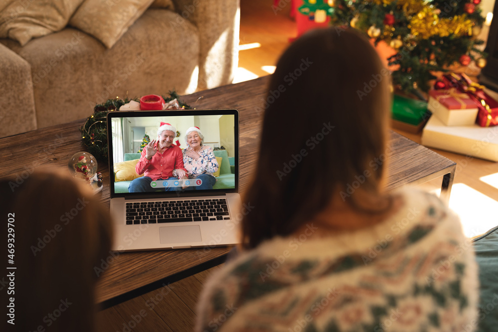 母亲和女儿与快乐的高加索老年祖父母进行笔记本电脑圣诞视频通话