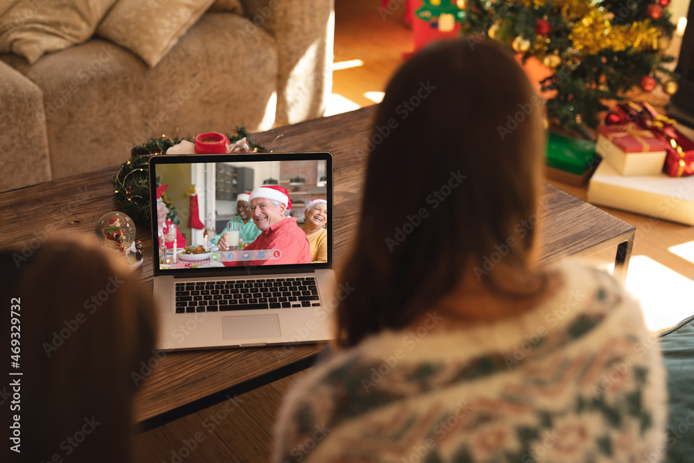 母女俩与快乐、多元化的资深朋友进行笔记本电脑圣诞视频通话