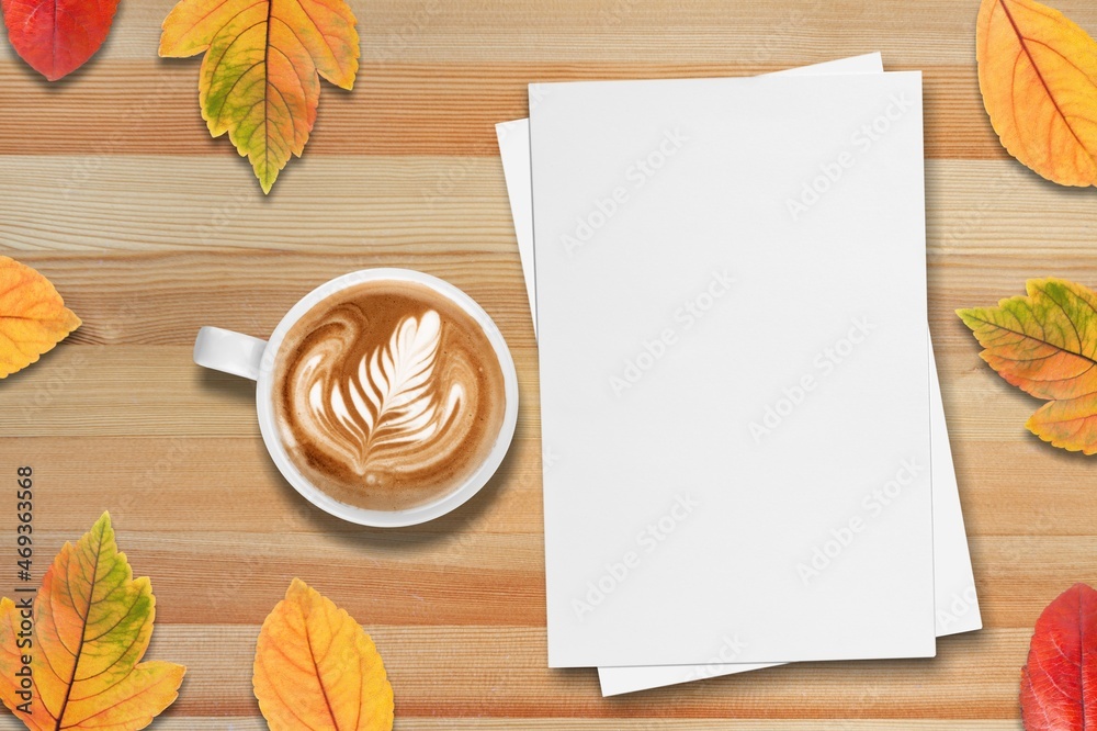 秋天的心情。一杯咖啡，笔记本，木质背景上的秋叶。