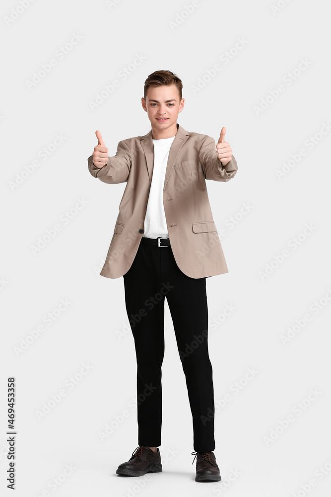 穿着夹克的青少年男孩在白色背景上竖起大拇指