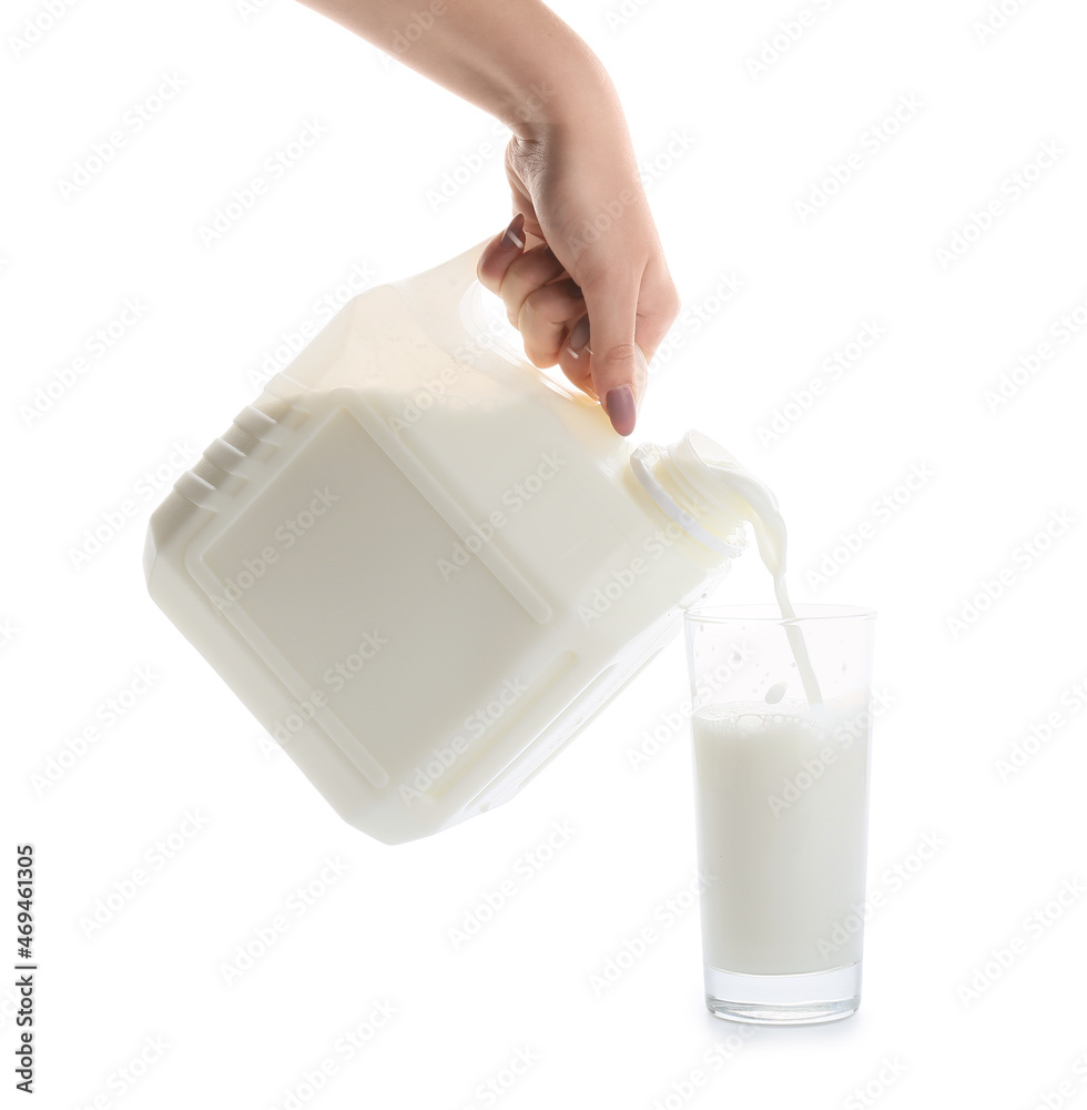 Woman pouring milk from gallon container into glass on white background