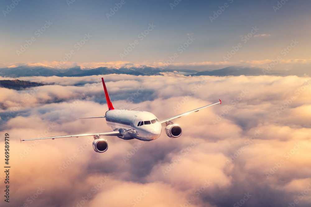 夏天日落时，飞机在云层上方飞行。有客机的风景，很美