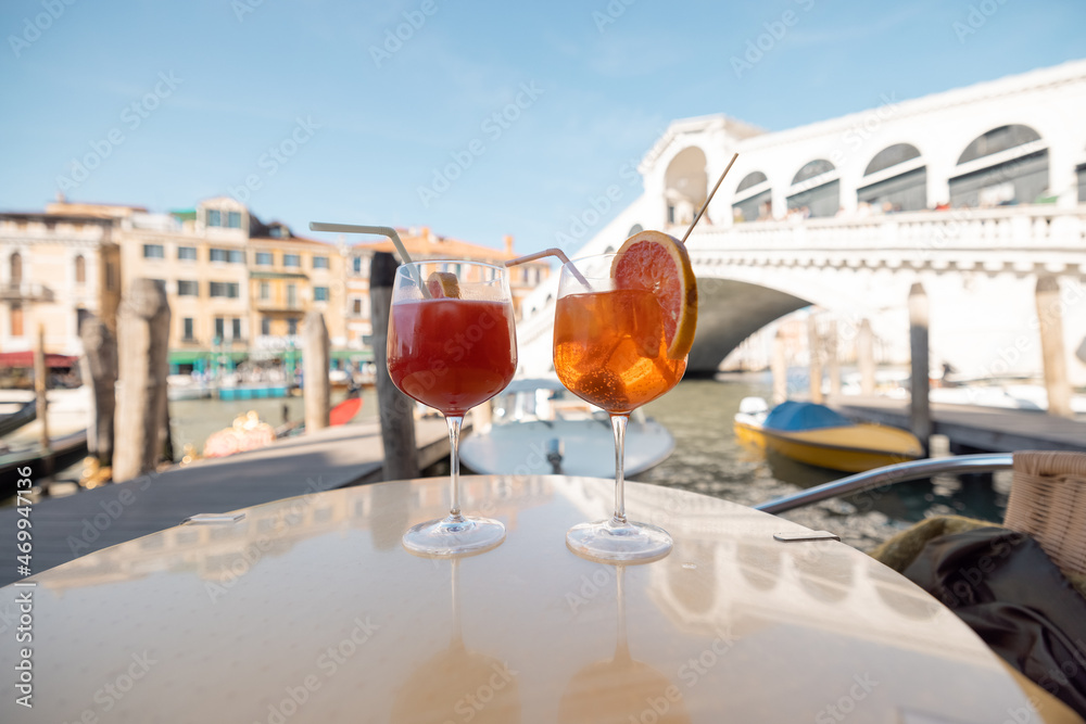 威尼斯大运河和里亚托山脊附近户外咖啡馆的桌子上放着两杯夏季鸡尾酒