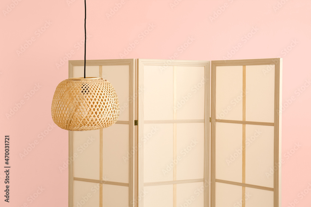 时尚的折叠屏幕和墙壁背景上的柳条灯