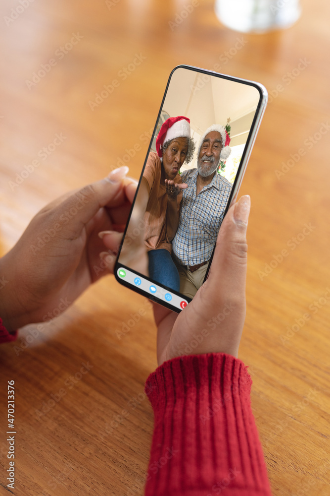 在圣诞视频通话屏幕上与快乐的非洲裔美国老夫妇牵手智能手机