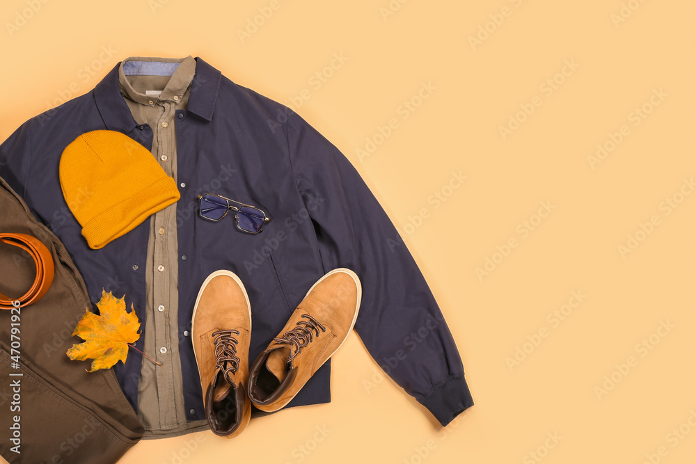 时尚的男性夹克、裤子、腰带、帽子、鞋子、眼镜和彩色背景的秋叶