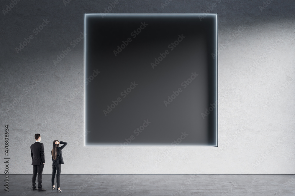 商人和女人站在极简主义的混凝土室内，抽象干净的黑色方形po