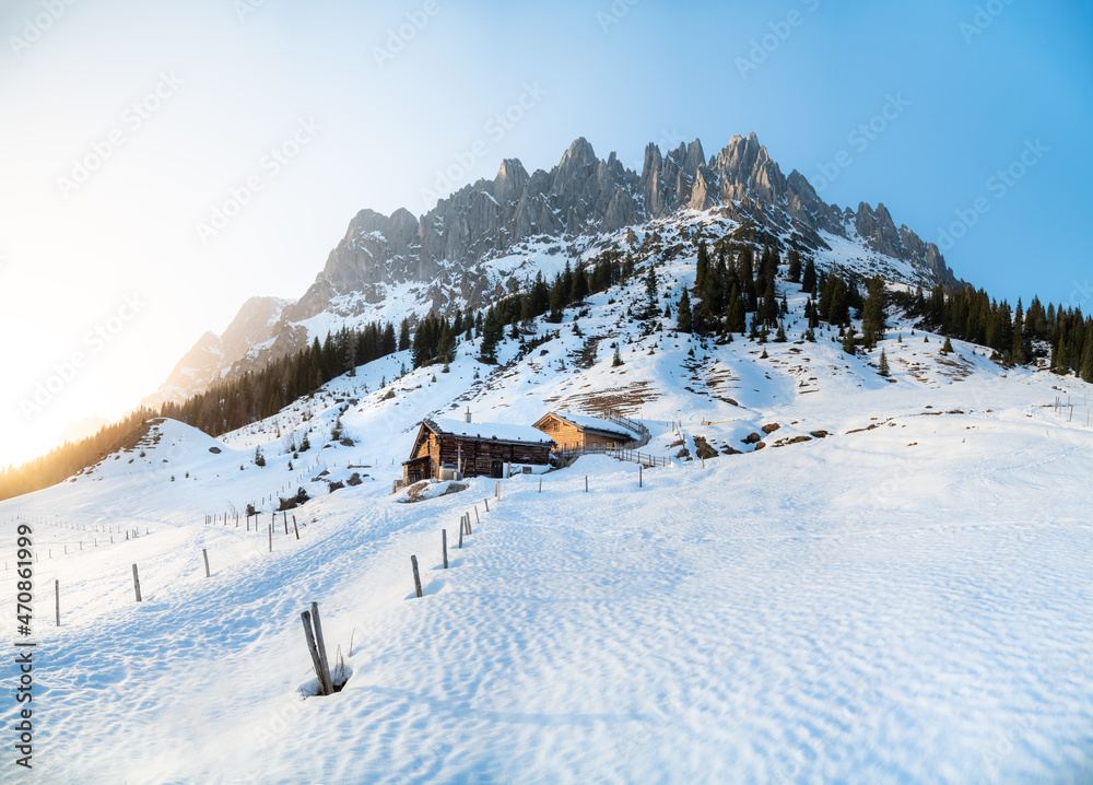 阿尔卑斯山的冬季仙境山景，日落时有传统的山间小屋