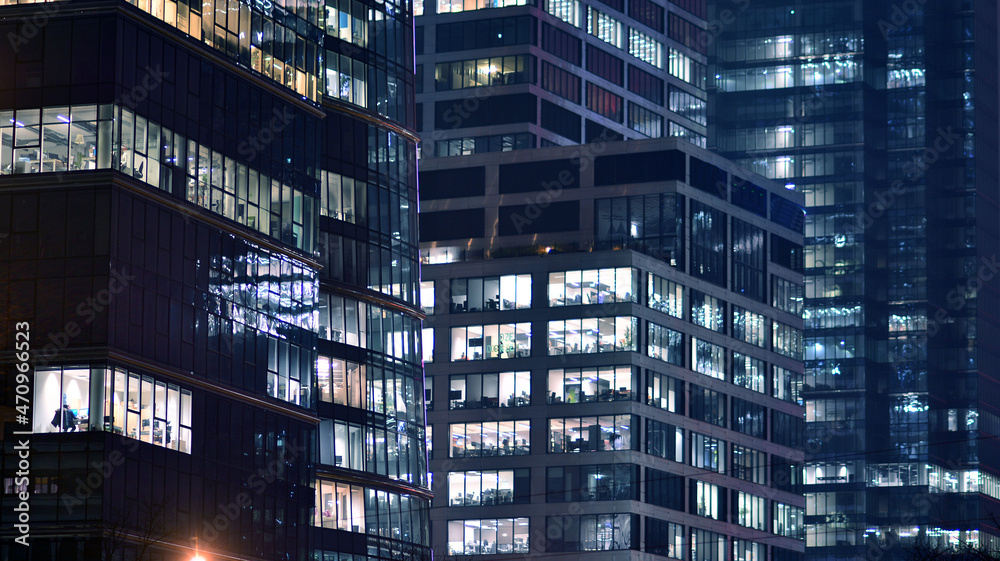夜间企业建筑-商业概念。玻璃墙办公楼。现代办公窗口