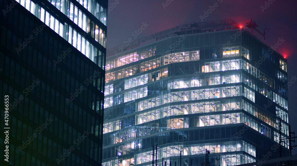 夜间企业建筑-商业理念。玻璃墙办公楼。现代办公窗