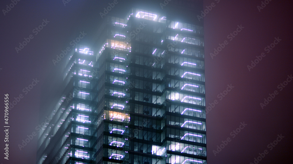 夜间企业建筑-商业概念。玻璃墙办公楼。现代办公窗户